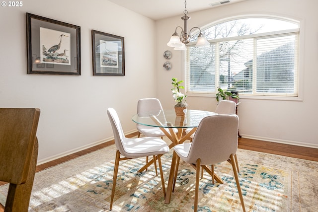 dining room with wood-type flooring and a chandelier