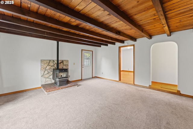 123 Scenic View Dr, Longview, WA 98632 - unfurnished living room featuring carpet floors, a wooden ceiling with exposed beams, a wood stove, and arched walkways
