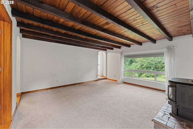123 Scenic View Dr, Longview, WA 98632 - unfurnished living room with a wood stove, carpet, a wood ceiling with exposed beams, and arched walkways