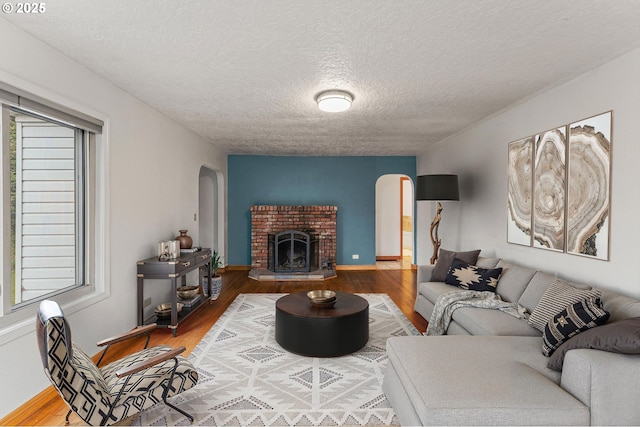 123 Scenic View Dr, Longview, WA 98632 - living area featuring arched walkways, wood finished floors, a textured ceiling, and a fireplace
