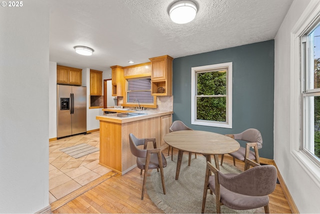 123 Scenic View Dr, Longview, WA 98632 - kitchen with stainless steel fridge with ice dispenser, open shelves, a peninsula, healthy amount of natural light, and a textured ceiling