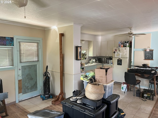 76464 High St, Oakridge, OR 97463 - kitchen with freestanding refrigerator, a ceiling fan, light tile patterned floors, and crown molding