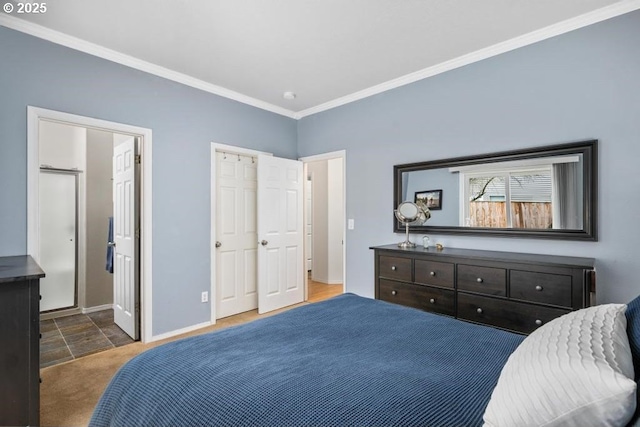 bedroom with baseboards, ensuite bath, and crown molding