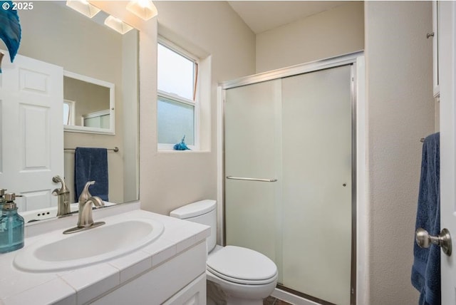 bathroom with vanity, a shower stall, and toilet