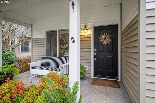 view of exterior entry featuring covered porch