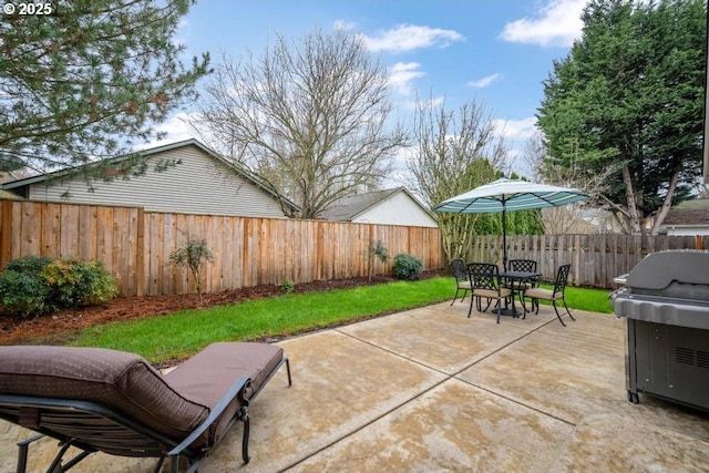 view of patio with grilling area, outdoor dining area, and a fenced backyard