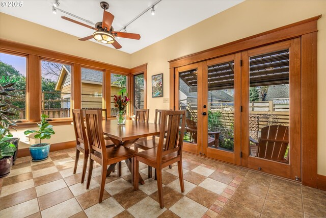 sunroom / solarium featuring track lighting and french doors
