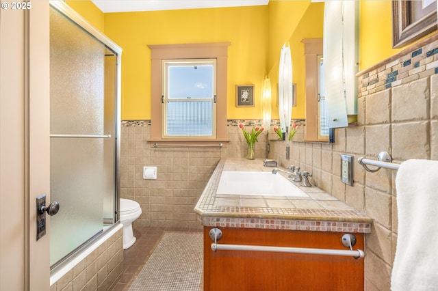 full bath featuring tile walls, tile patterned floors, a wainscoted wall, vanity, and toilet