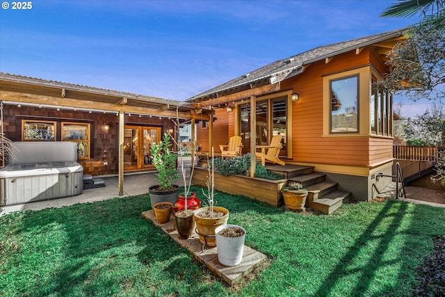 rear view of property with french doors, a patio, and a yard