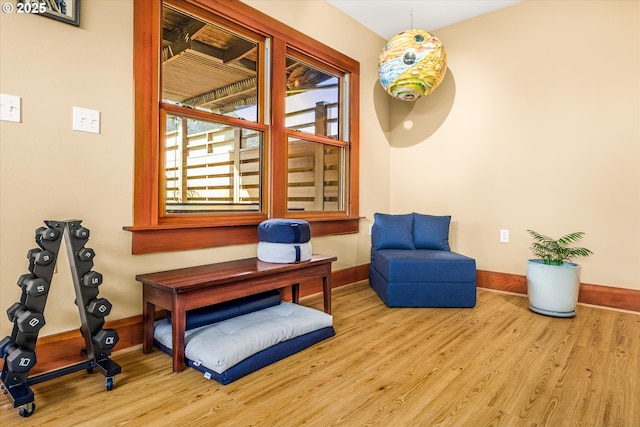 sitting room with baseboards and wood finished floors
