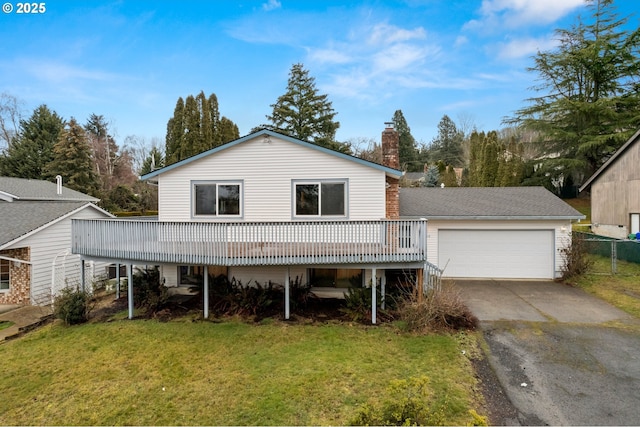 view of front facade with a garage, a front yard, and a deck