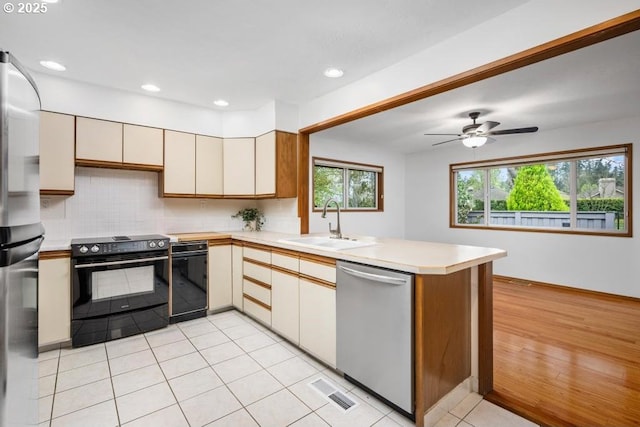 9998 SW French Prairie Rd, Wilsonville, OR 97070 - kitchen featuring light countertops, a peninsula, a sink, and stainless steel appliances