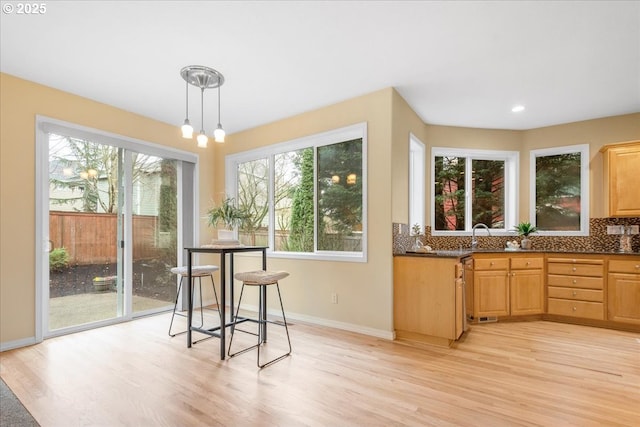 dining area featuring light wood-style floors, baseboards, and a wealth of natural light