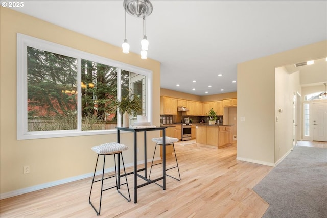 dining space featuring recessed lighting, baseboards, and light wood-type flooring