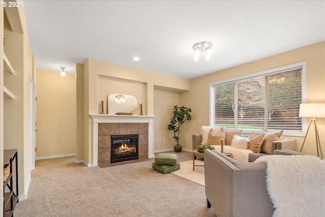 carpeted living area with recessed lighting, a tile fireplace, and baseboards