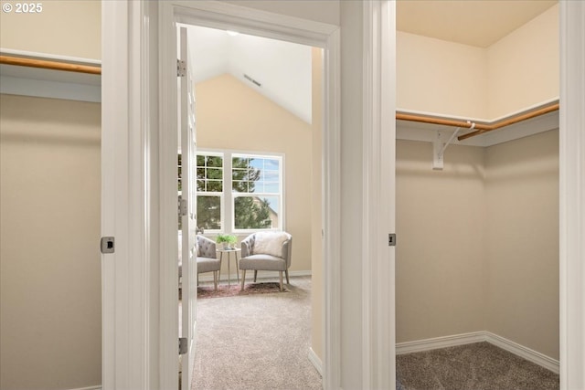 walk in closet featuring carpet flooring, visible vents, and vaulted ceiling