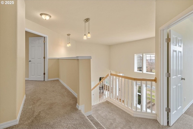 hall featuring carpet, an upstairs landing, and baseboards