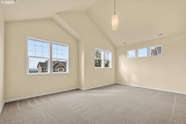 carpeted spare room with visible vents, baseboards, and lofted ceiling