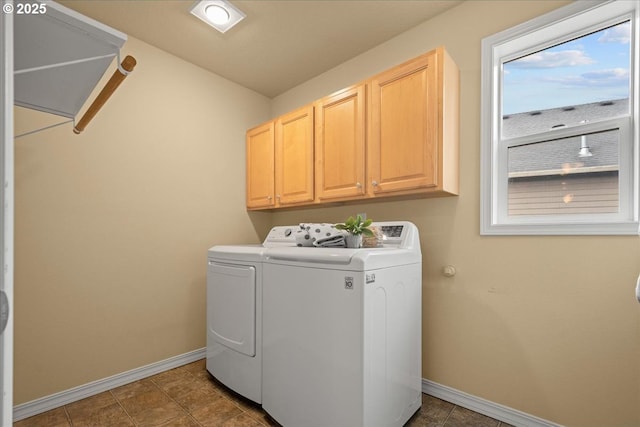 laundry room with dark tile patterned floors, cabinet space, baseboards, and washing machine and clothes dryer