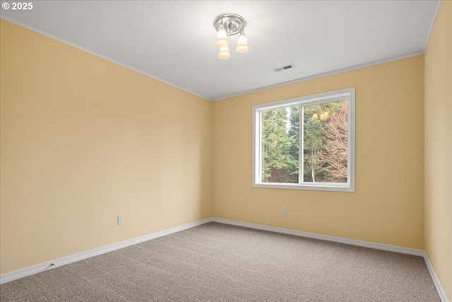 carpeted spare room featuring visible vents and baseboards