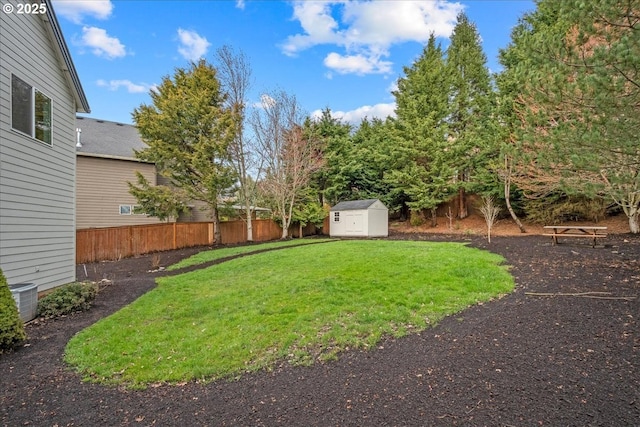 view of yard with central AC unit, an outdoor structure, a storage unit, and fence