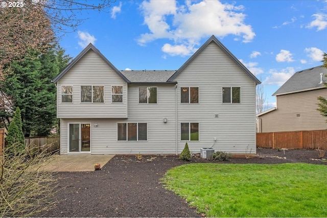 back of property featuring central air condition unit, fence, a lawn, and a patio area