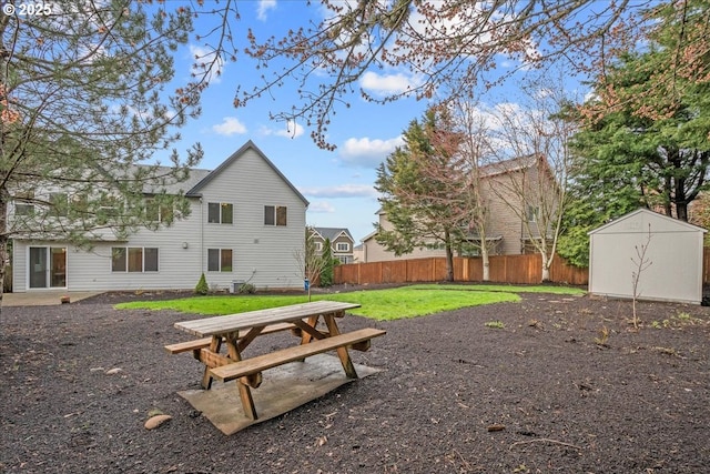 view of yard with a shed, an outdoor structure, and fence