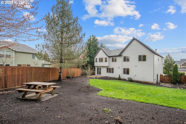 back of property with a patio area, a yard, and a fenced backyard