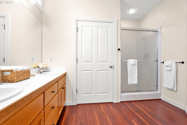 bathroom with hardwood / wood-style flooring, vanity, and an enclosed shower