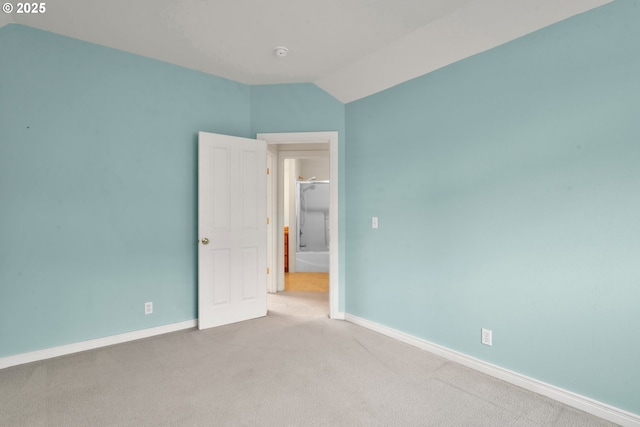 spare room with lofted ceiling and light carpet