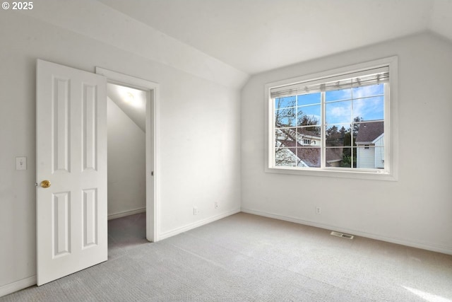 unfurnished bedroom with lofted ceiling and light carpet