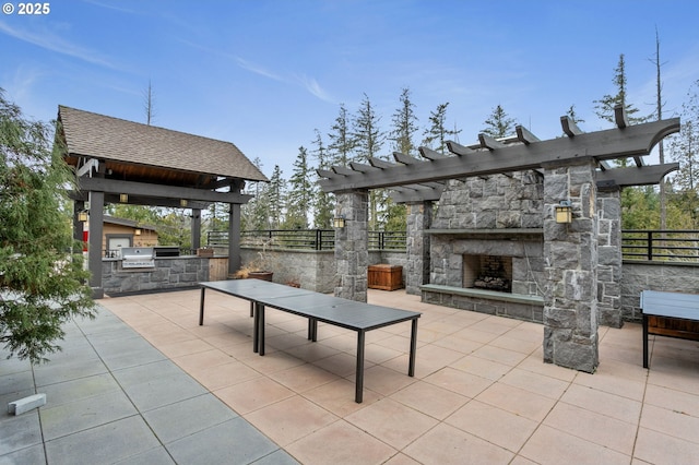 view of patio / terrace featuring area for grilling and an outdoor stone fireplace