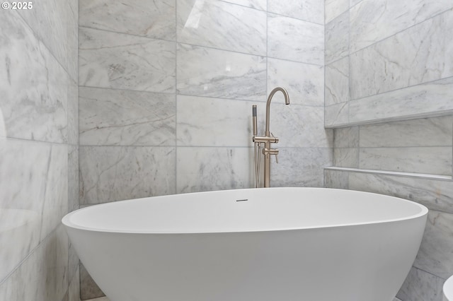 bathroom featuring a freestanding bath and tile walls