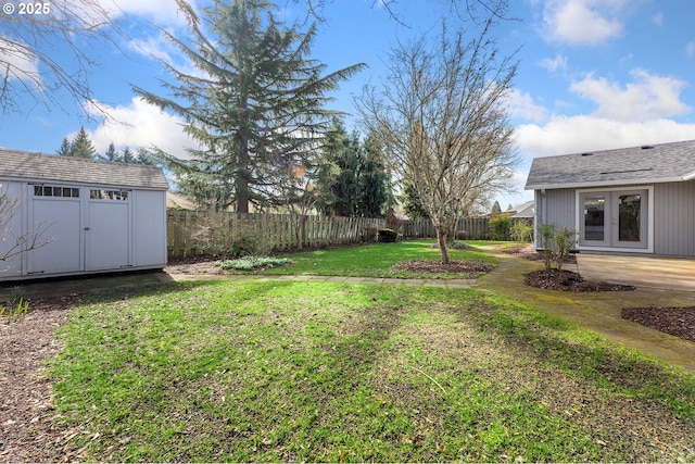 view of yard with a patio, a fenced backyard, an outdoor structure, french doors, and a storage unit