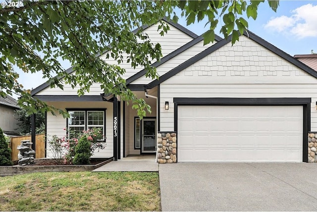 59673 Oak Ridge St, Saint Helens, OR 97051 - ranch-style house with concrete driveway, stone siding, an attached garage, and a front yard