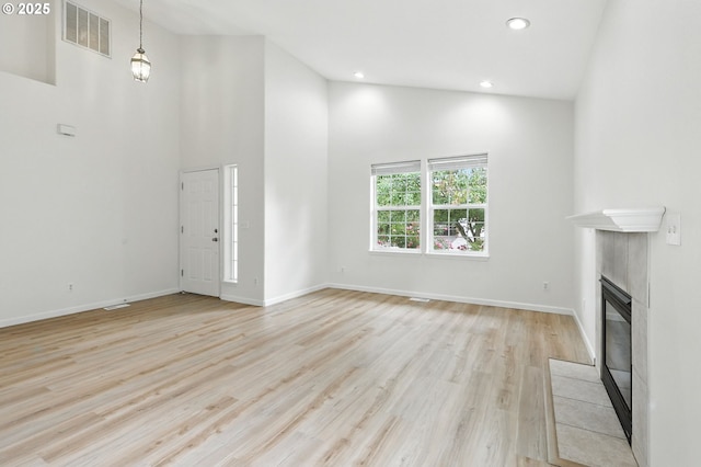 59673 Oak Ridge St, Saint Helens, OR 97051 - unfurnished living room featuring light wood-style flooring, a tiled fireplace, high vaulted ceiling, and recessed lighting