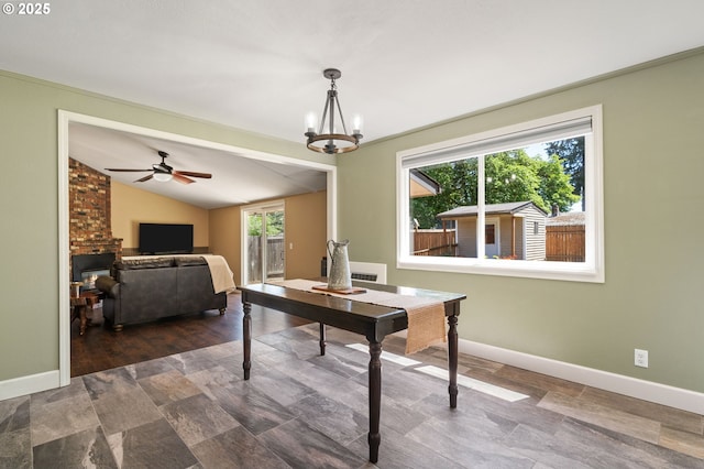 dining room featuring lofted ceiling, baseboards, a ceiling fan, and a chandelier