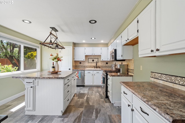 kitchen with stainless steel appliances, a sink, decorative backsplash, white cabinets, and recessed lighting