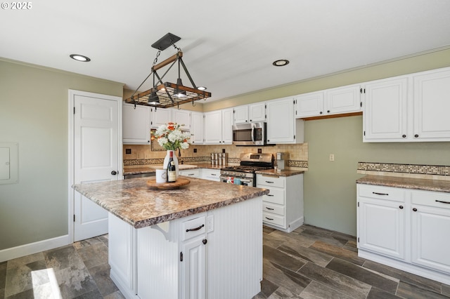 kitchen with appliances with stainless steel finishes, white cabinets, decorative backsplash, a center island, and recessed lighting
