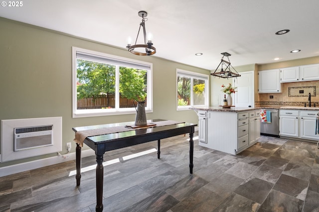 kitchen with dishwasher, white cabinetry, decorative backsplash, a chandelier, and a wall mounted air conditioner