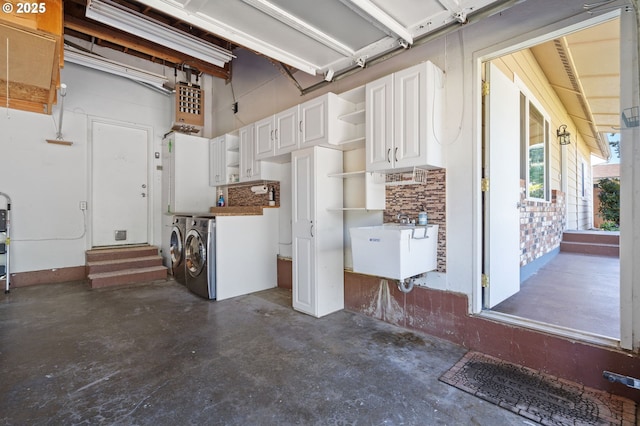 garage featuring washer and clothes dryer and a sink