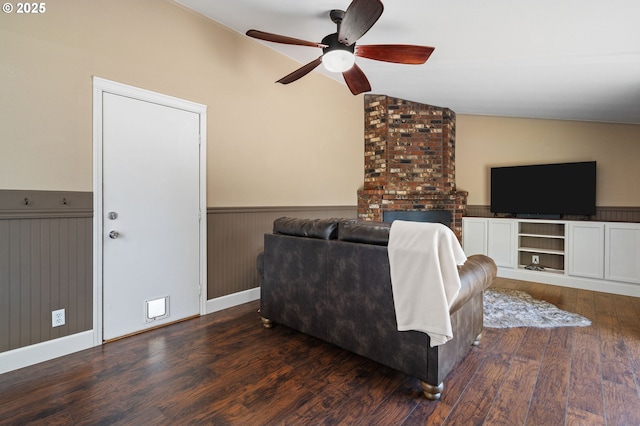 living area featuring lofted ceiling, wainscoting, wood finished floors, and ceiling fan