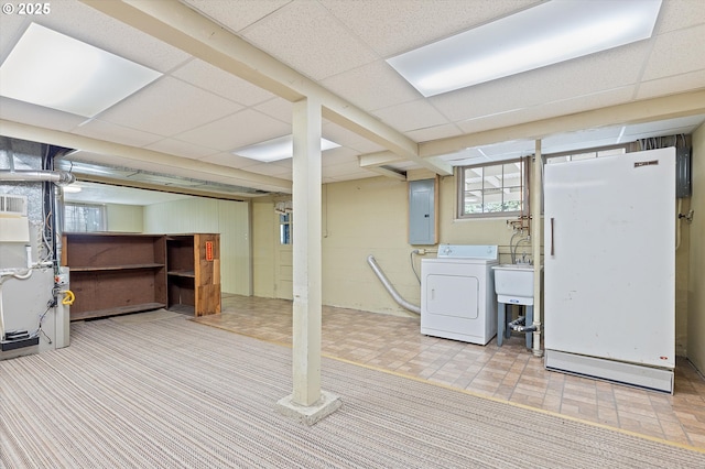 basement featuring washer / dryer, heating unit, a drop ceiling, and electric panel