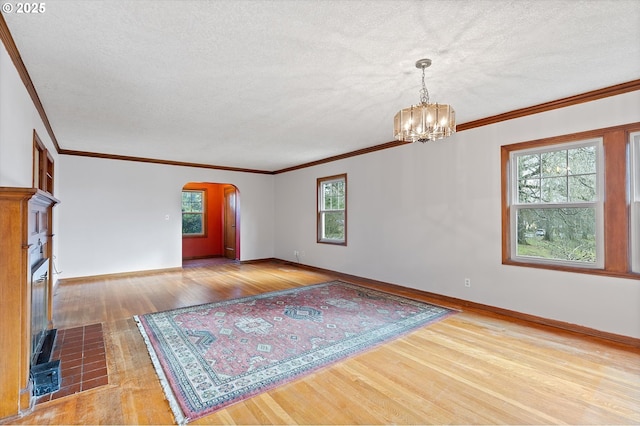 unfurnished room featuring crown molding, a chandelier, light hardwood / wood-style floors, and a textured ceiling