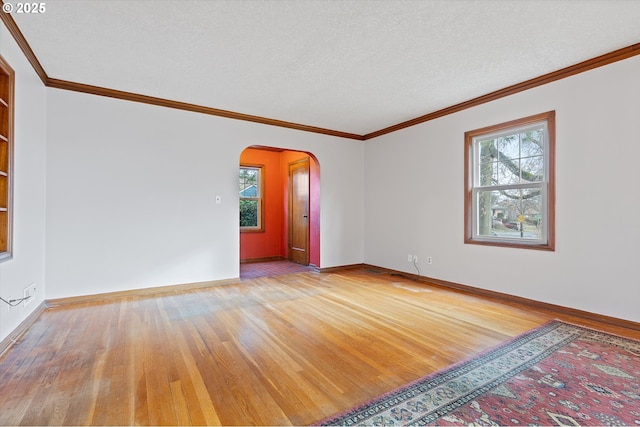 unfurnished room featuring ornamental molding, a textured ceiling, and light hardwood / wood-style flooring