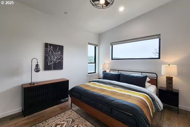 280 NW Huckleberry St, Waldport, OR 97394 - bedroom featuring wood finished floors, baseboards, and lofted ceiling