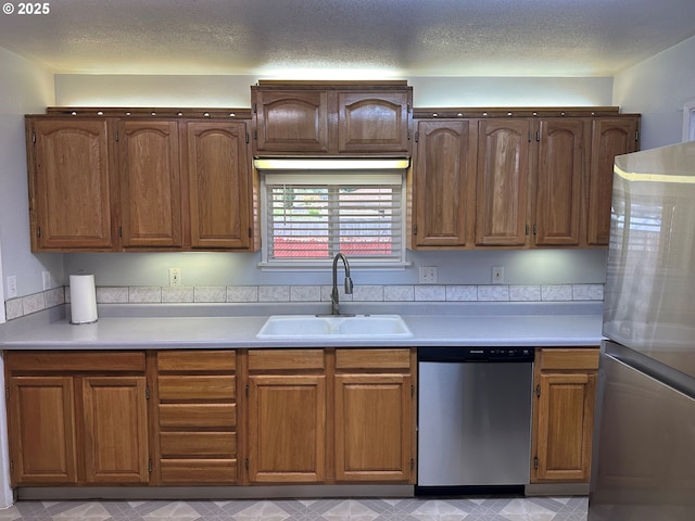 2735 W Jay Ave, Roseburg, OR 97471 - kitchen featuring appliances with stainless steel finishes, a sink, light countertops, a textured ceiling, and brown cabinets