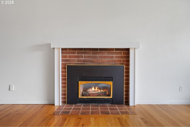 10438 NE Davis St, Portland, OR 97220 - detailed view of a warm lit fireplace, wood finished floors, and baseboards