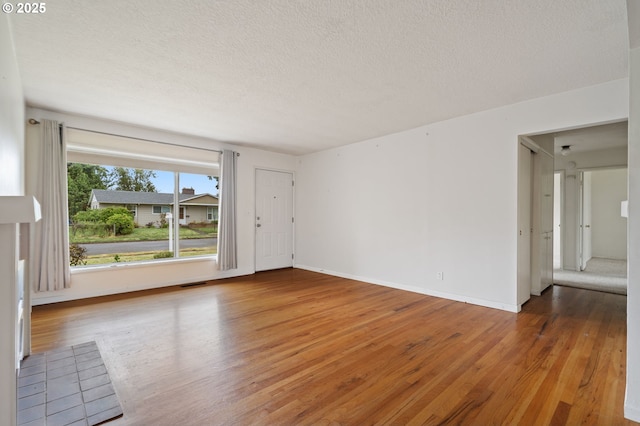 10438 NE Davis St, Portland, OR 97220 - unfurnished room with wood finished floors, a textured ceiling, and baseboards