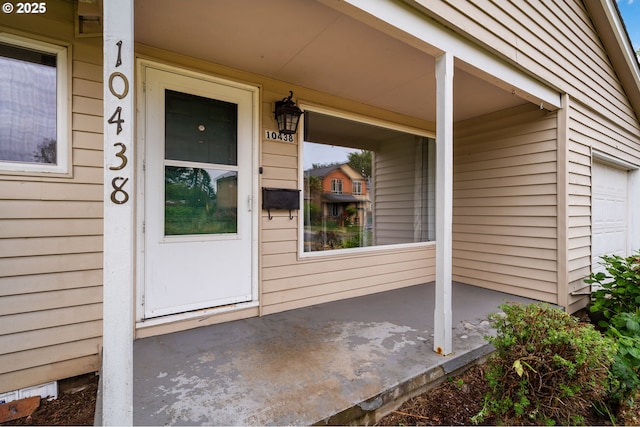 10438 NE Davis St, Portland, OR 97220 - doorway to property with covered porch and a garage